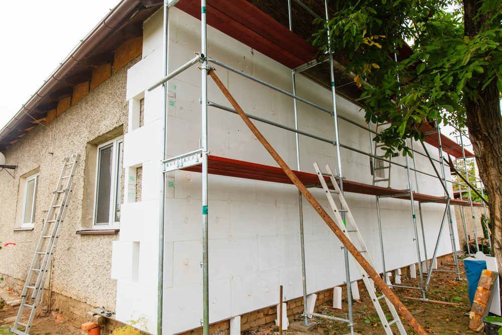 Maison contemporaine minimaliste avec façade blanche, garage intégré et porte d'entrée en bois