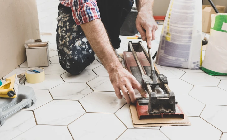 Chantier de rénovation de façade d'immeuble avec ouvrier travaillant sur échafaudage tubulaire métallique