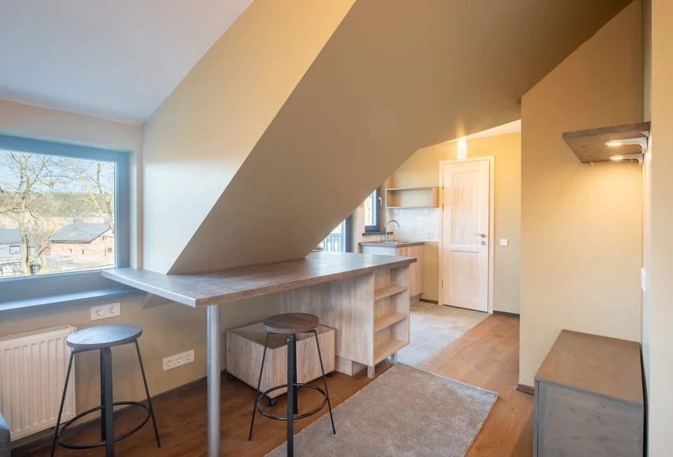 Intérieur d'un chantier de rénovation avec ouvrier appliquant un enduit ou peinture blanche au pinceau sur une surface murale