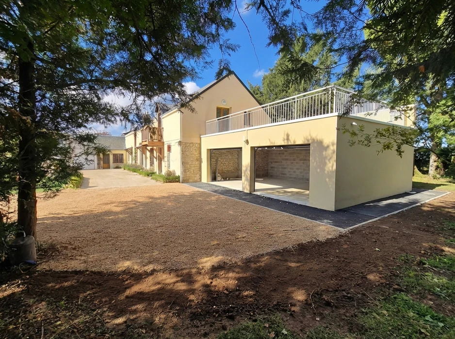 Intérieur d'un chantier de rénovation avec ouvrier appliquant un enduit ou peinture blanche au pinceau sur une surface murale