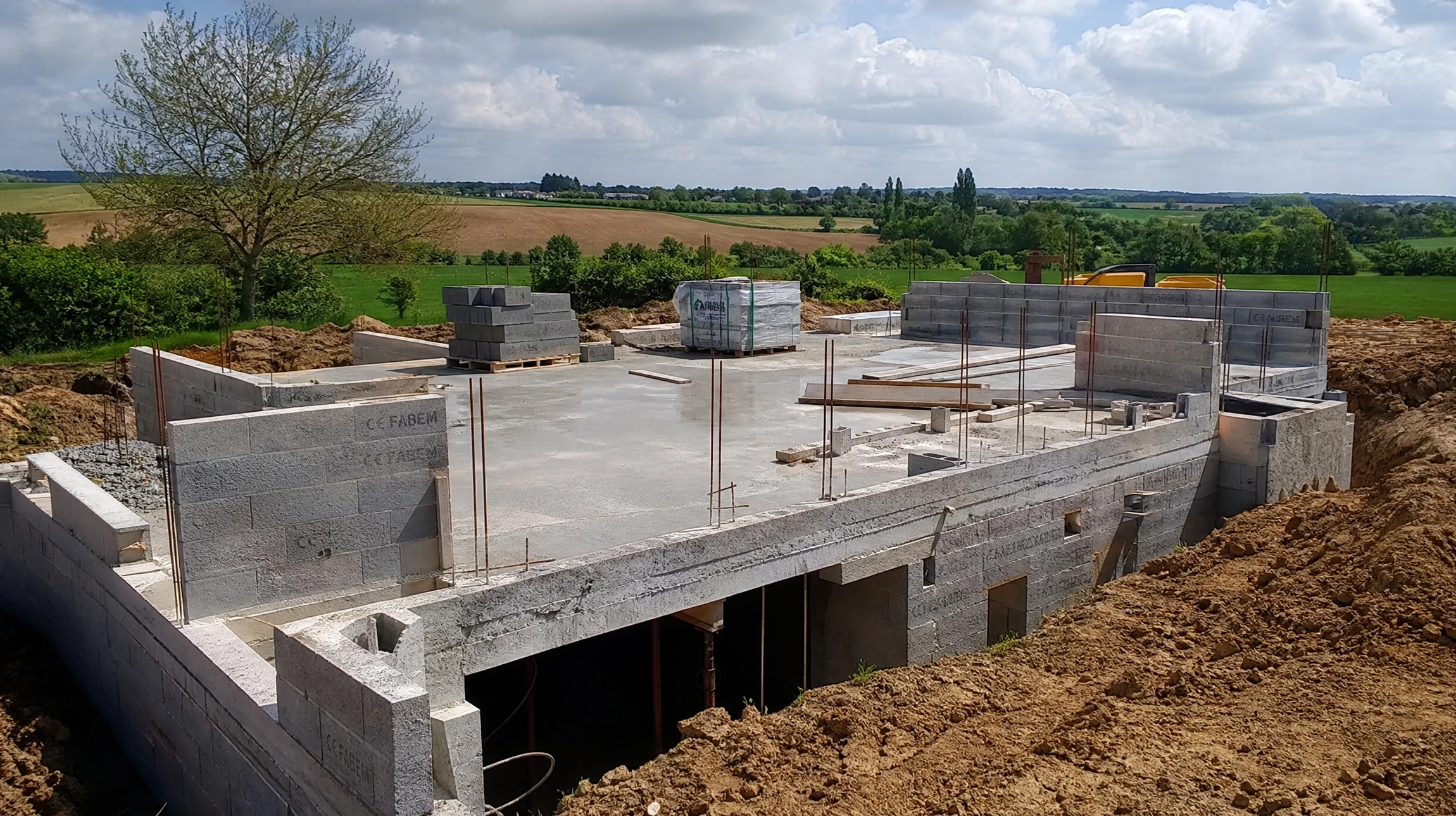Chantier de construction extérieur avec fondations en béton armé fraîchement coulées
